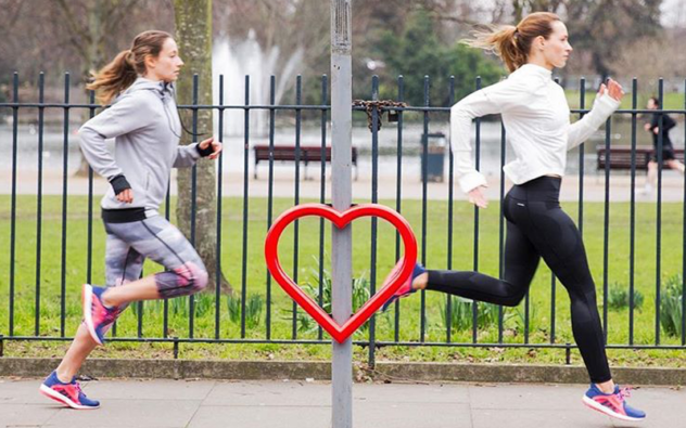 Two joggers running past a Cyclehoop Love Hoop