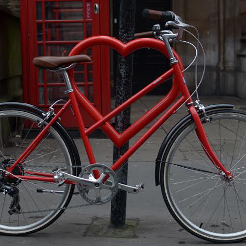 An installed Cyclehoop Tough Love Bike Stand in red, with bicycle attached