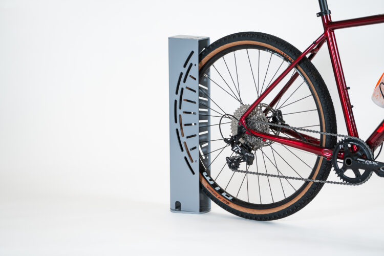 A rear bike wheel inserted into a rectangular metal wheel stand.