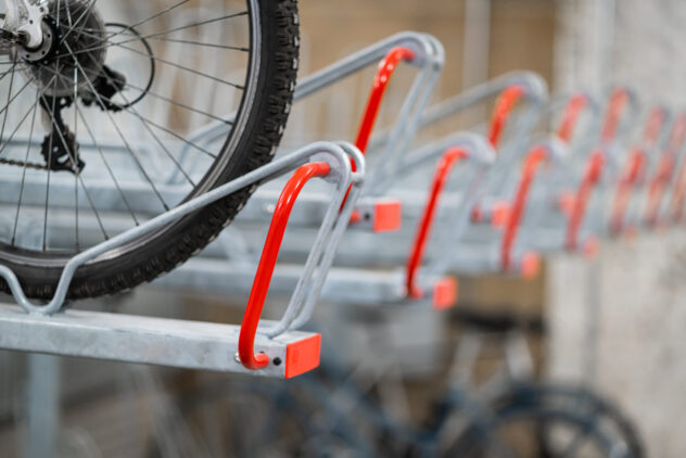 A close-up of a bike wheel secured into the top rack of a two-tier bike storage rack.