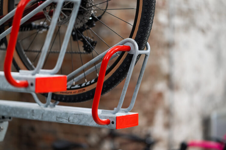 A bike wheel secured in a metal bike rack.