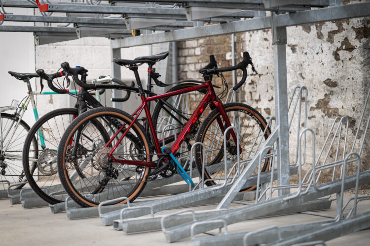 Bikes parked in metal bike racks inside a bike storage room.