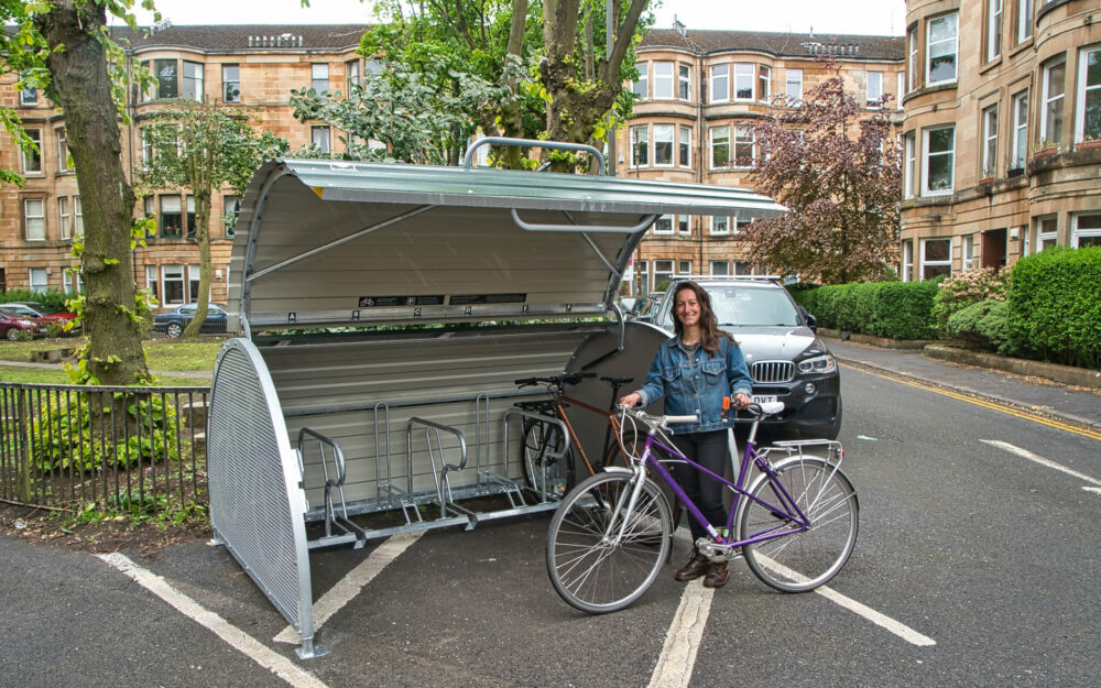 Woman with bikehangar secure on-street residential cycle parking in Glasgow