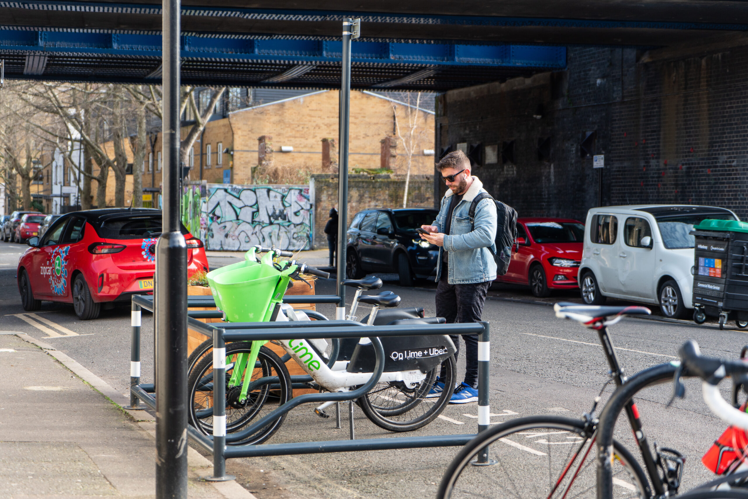 A man using a smart phone to unlock a dockless hire bike