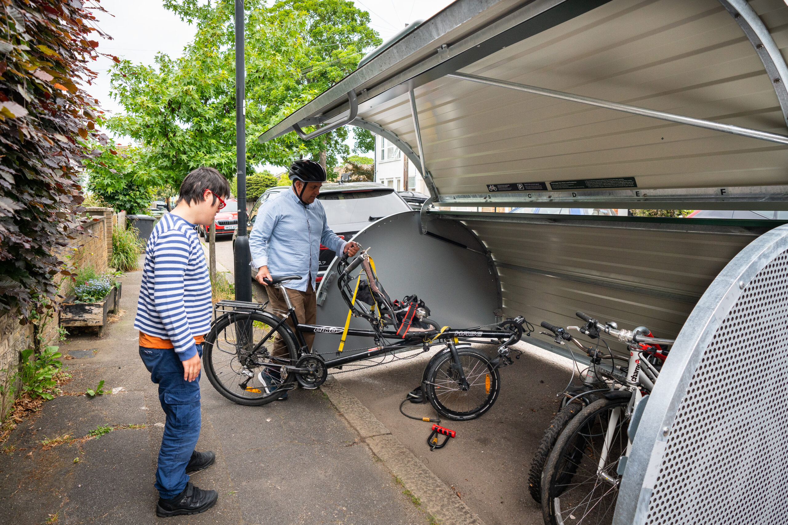 A father and son loading a recumbent bike into a Bikehangar