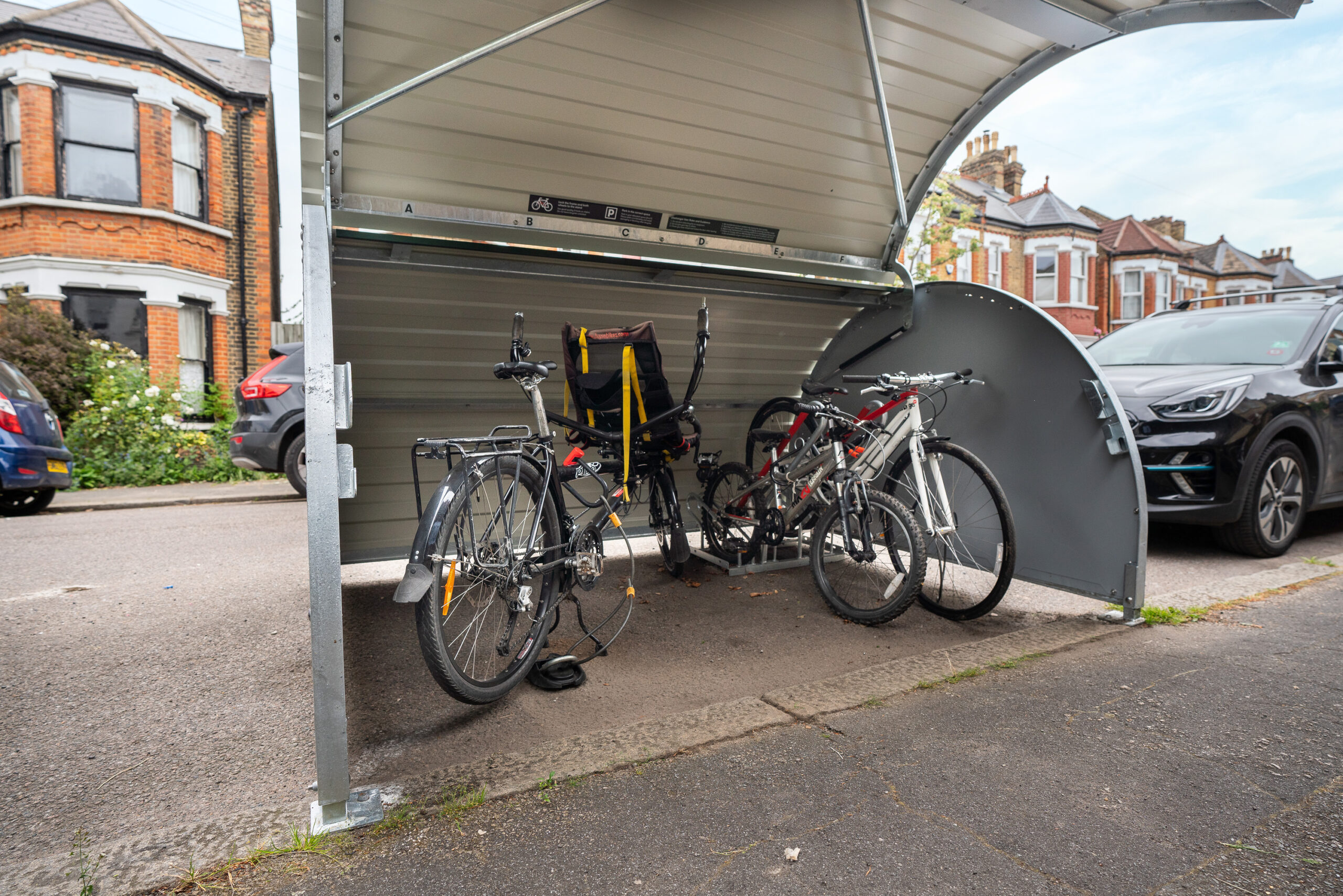 An adapted bikehangar interior with a recumbent bike and two other bicycles