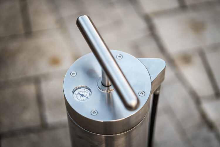 A close-up of the handle of a metal bike pump.