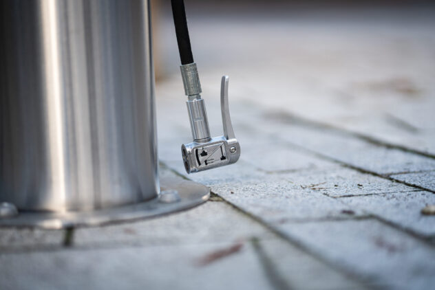 A close-up shot of the metal nozzle of a bicycle tire pump.