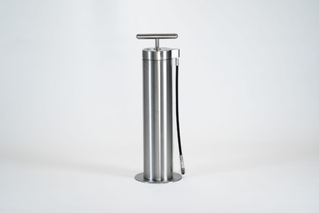 A tall, cylindrical metal bike tire pump.