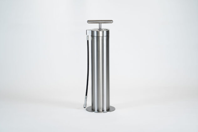 A tall, cylindrical metal bike tire pump.