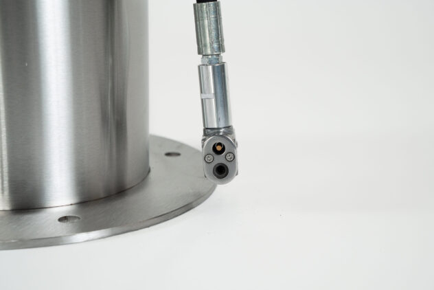 "A close-up shot of the metal nozzle of a bicycle tire pump. "